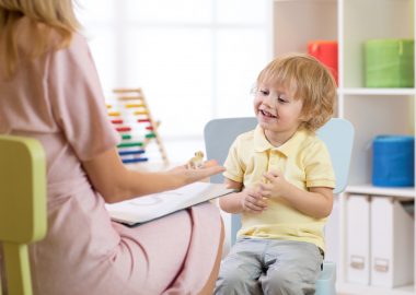 Child psychologist working with kid boy in office