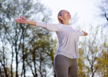 Being outdoors. Happy peaceful woman breathing fresh air while enjoying being outdoors