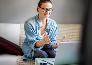 Young pretty european woman with glasses psychologist coach holds an online session on the internet, remote work from home, online consultations